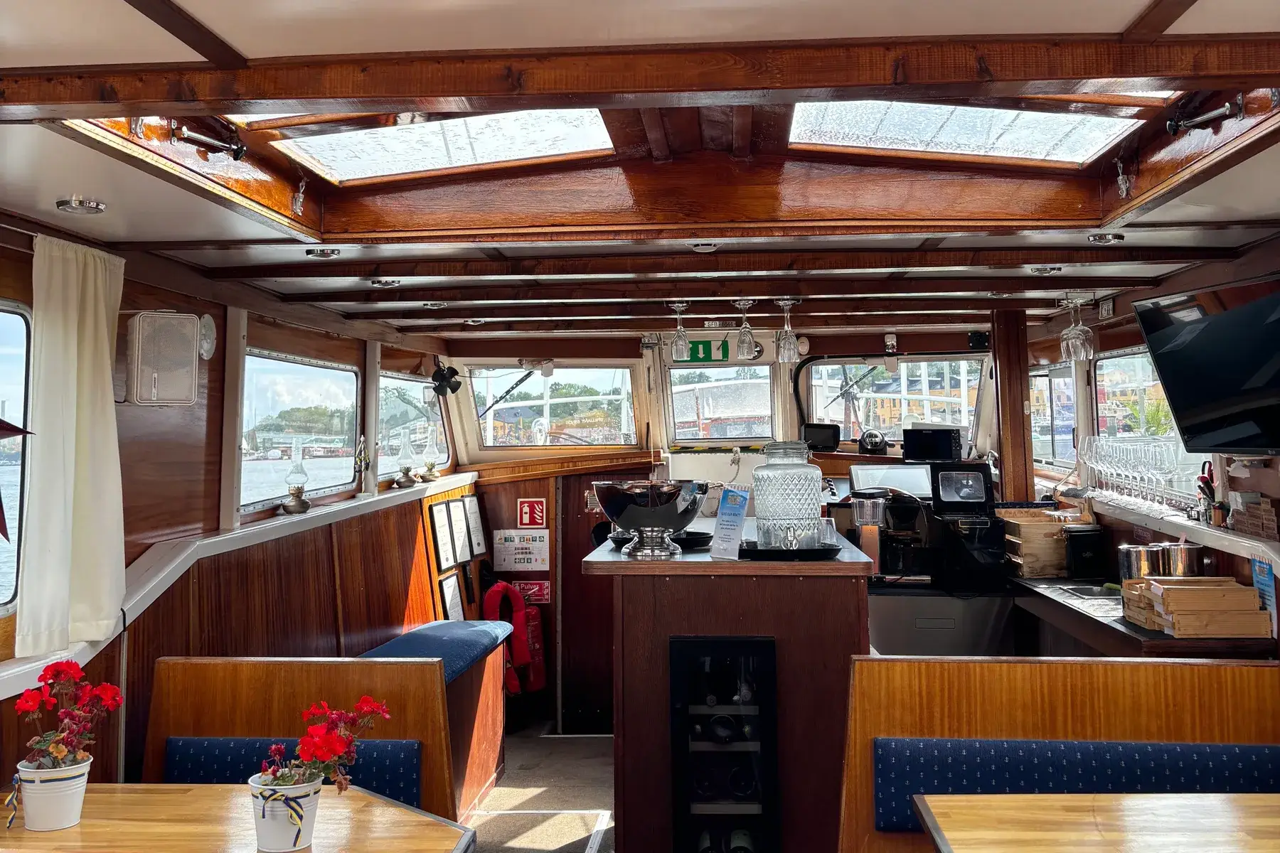 Inside the closed boat, with wood paneling, booth seating and a bar