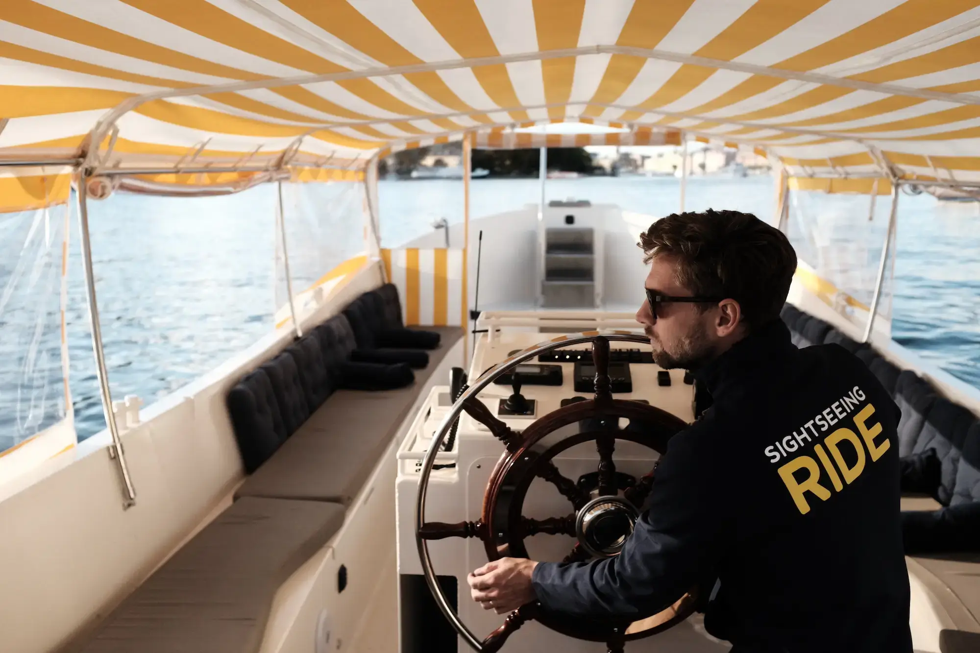 Electric Stockholm sightseeing boat with yellow striped canopy