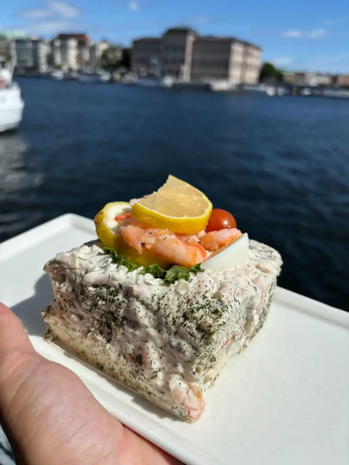 Schwedisches Garnelen-Sandwich auf einem Teller mit Stockholm im Hintergrund