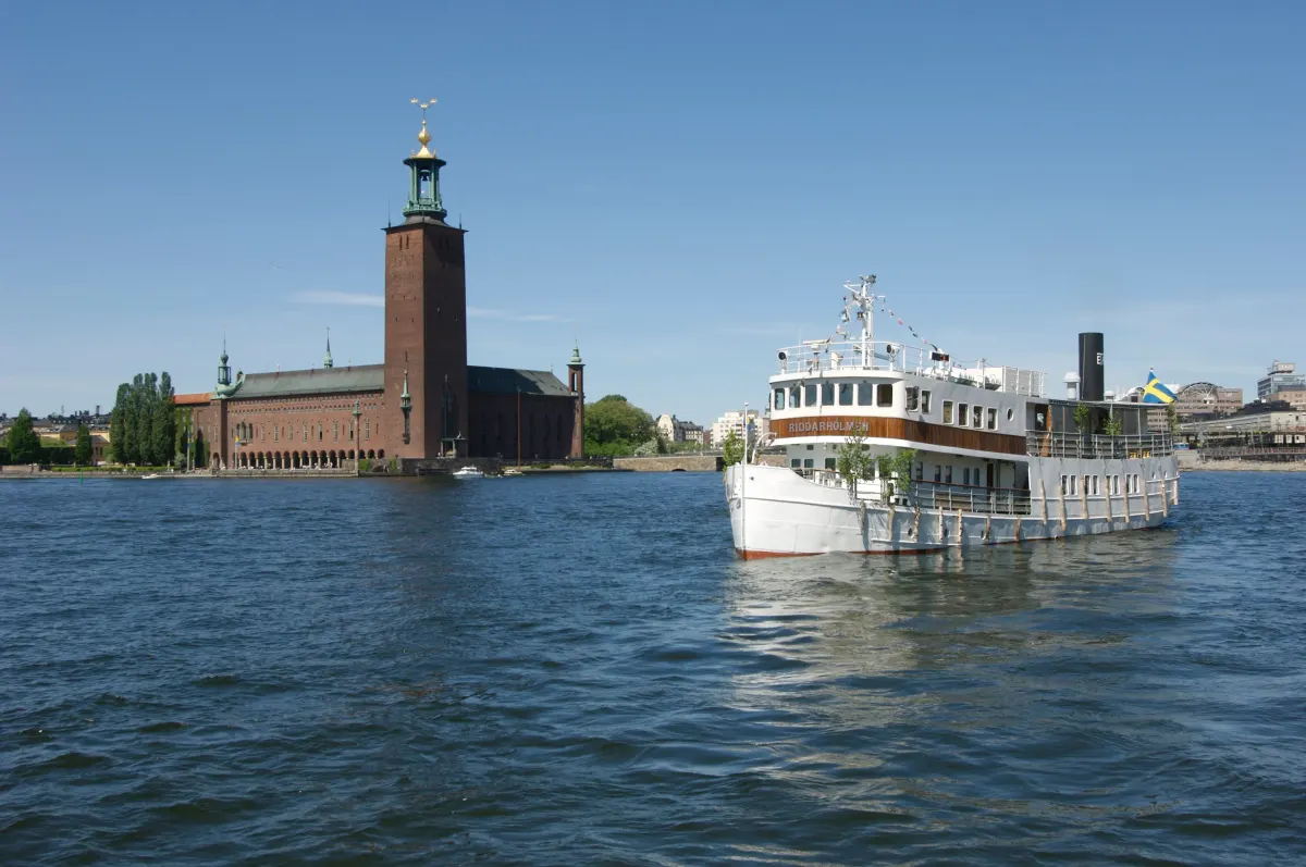 Båt framför Stockholms stadshus sett från Riddarfjärden