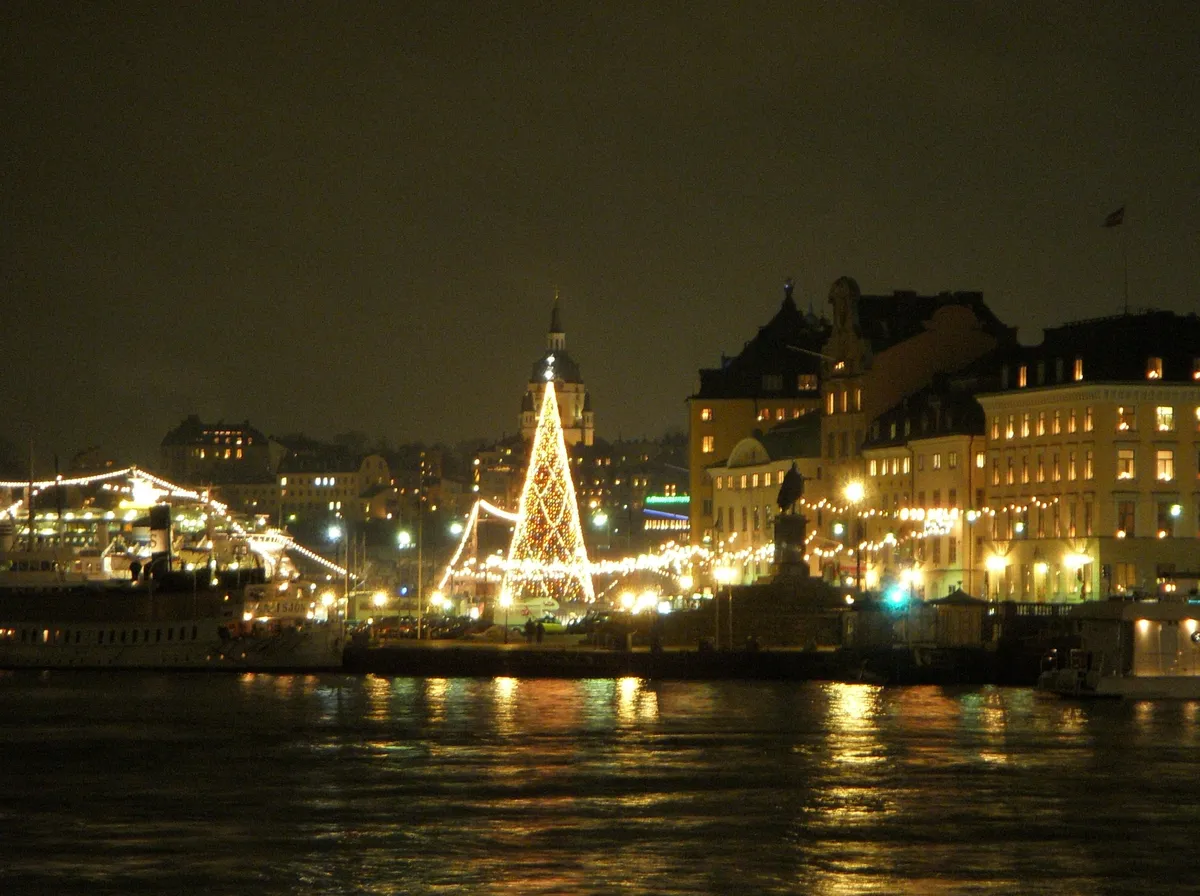 Utsikt över Gamla stan med en upplyst julgran vid vattnet första advent