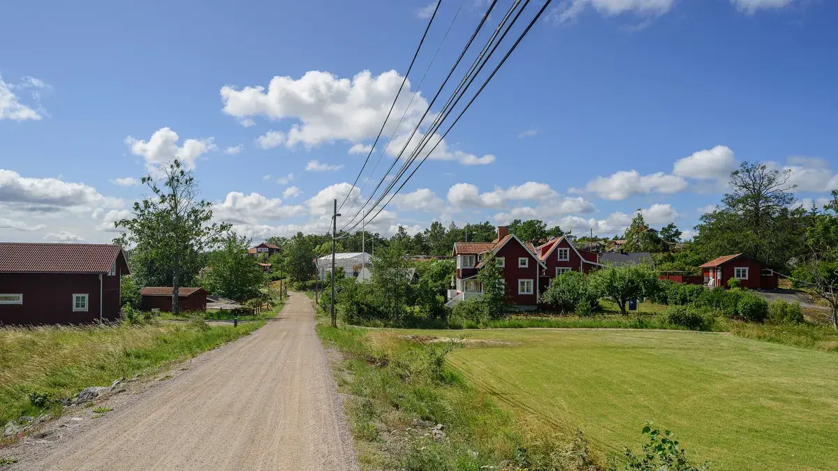A gravel road through the village of Ramsmora on Möja with red houses