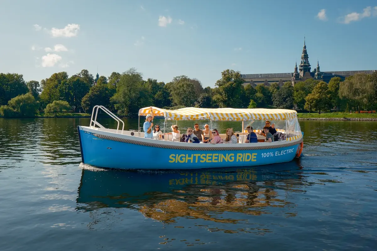 Sightseeing Rides blå eldrivna båt med guide och gäster på vattnet i Stockholm