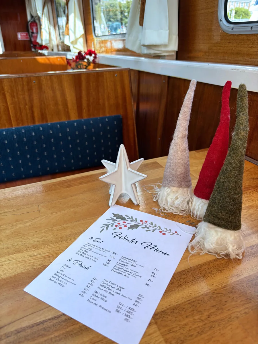 The winter menu on a table in the cabin next to tomte figures and a white star
